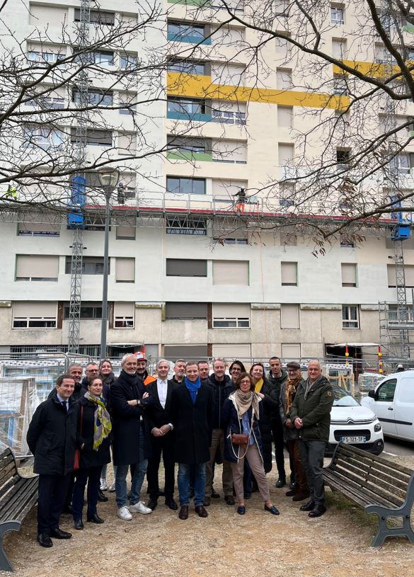 Groupe de personnes devant un immeuble en cours de réhabilitation