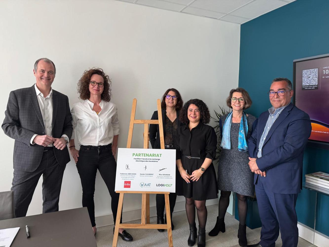 Photo de groupe de personne d'Erilia et Waat devant un panneau de signature de la convention